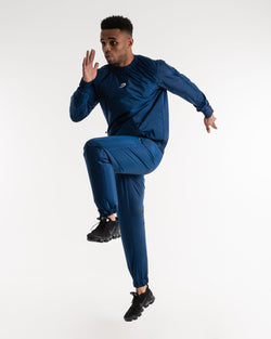 Man in a navy sauna suit tracksuit with a white boxraw logo on the chest as well as adjustable wrist straps and made from polyester.