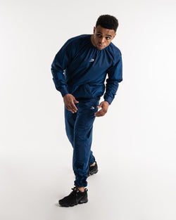 Man in a navy sauna suit tracksuit with a white boxraw logo on the chest as well as adjustable wrist straps and made from polyester.